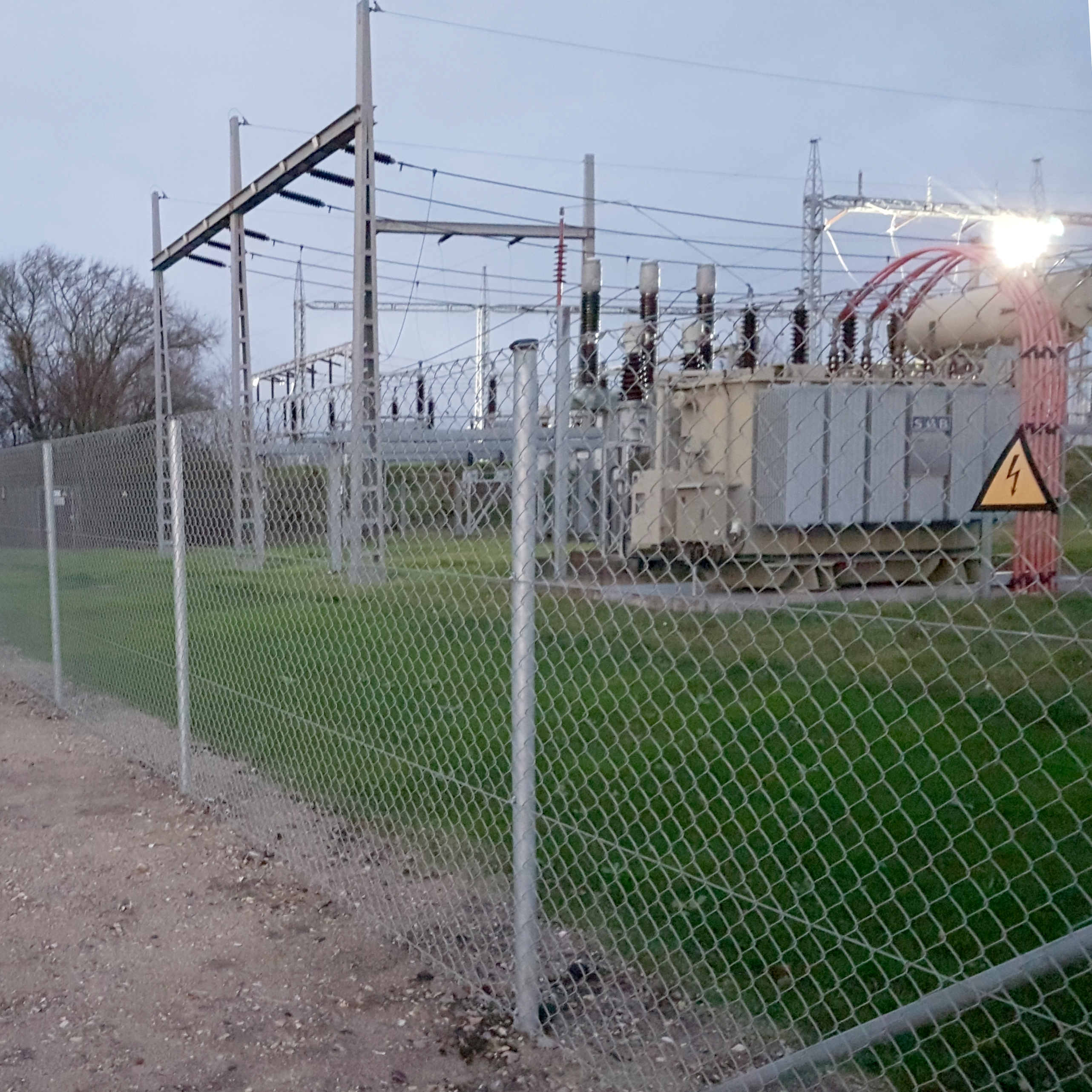 En transformatorstation är inhägnad med ett flätverksstängsel