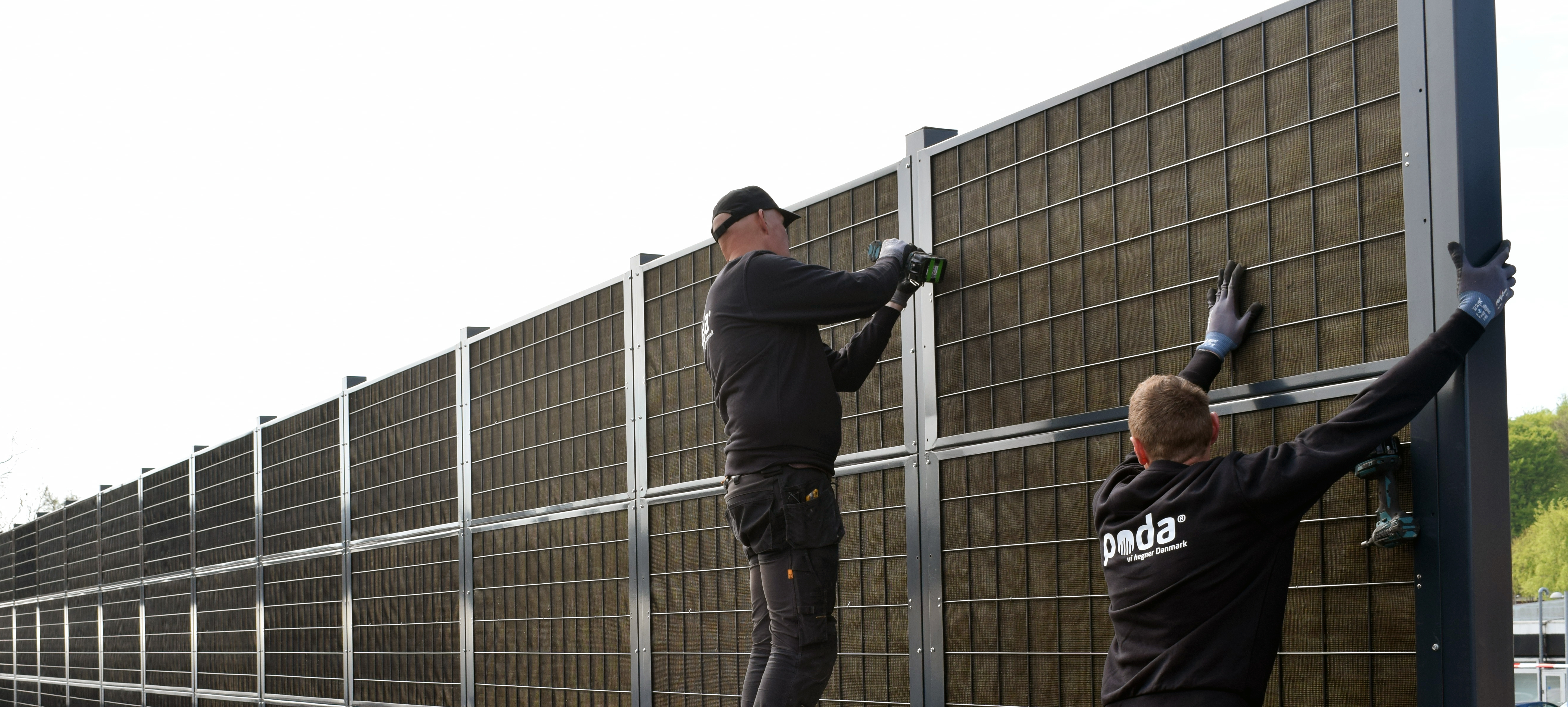 Två stängselsmontörer från Poda Stängsel monterar ett Noistop® Steel bullerplank.